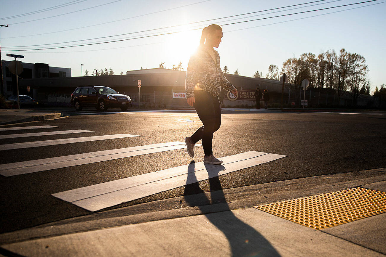 A pedestrian uses the crosswalk at 30th Street NE along 113th Avenue NE near Lake Stevens High School on Monday, Nov. 14, 2022 in Lake Stevens, Washington. (Olivia Vanni / The Herald)