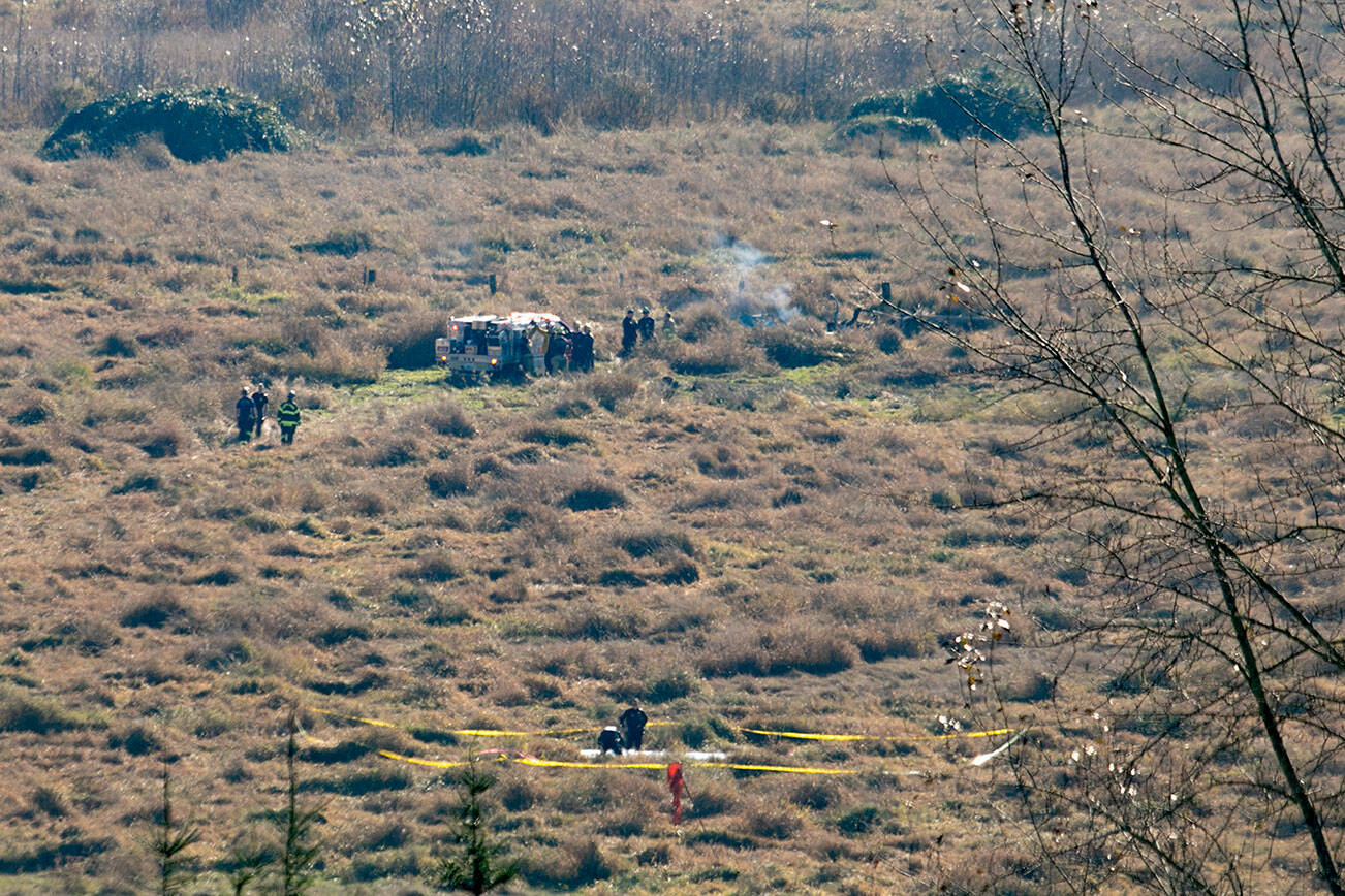 Emergency responders surround the wreckage of an airplane that crashed into a field along U.S. 2 just east of Snohomish on Friday, Nov. 18, 2022, in Snohomish, Washington. (Ryan Berry / The Herald)