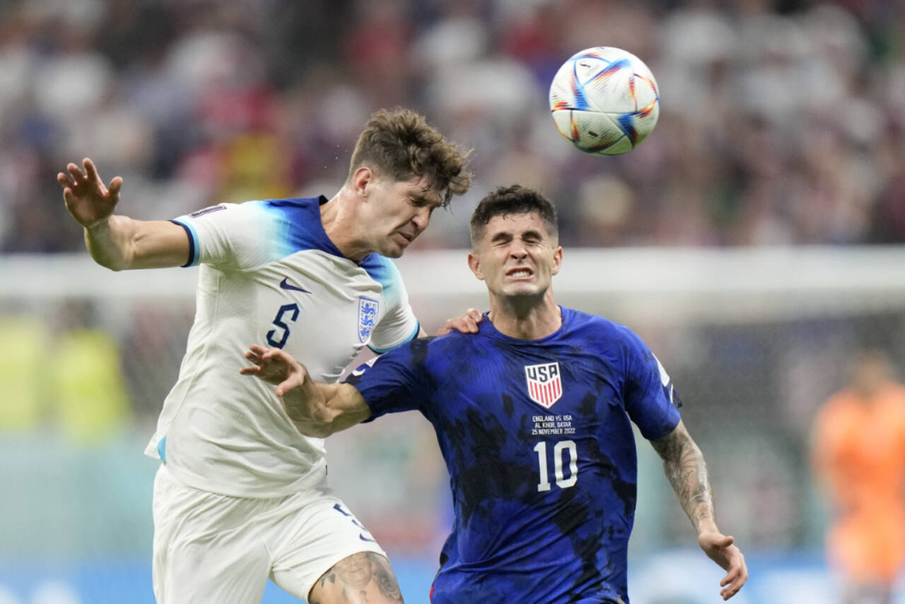 England’s John Stones vies for the ball with Christian Pulisic of the United States (right) during a World Cup match Friday at the Al Bayt Stadium in Al Khor, Qatar. (AP Photo/Luca Bruno)