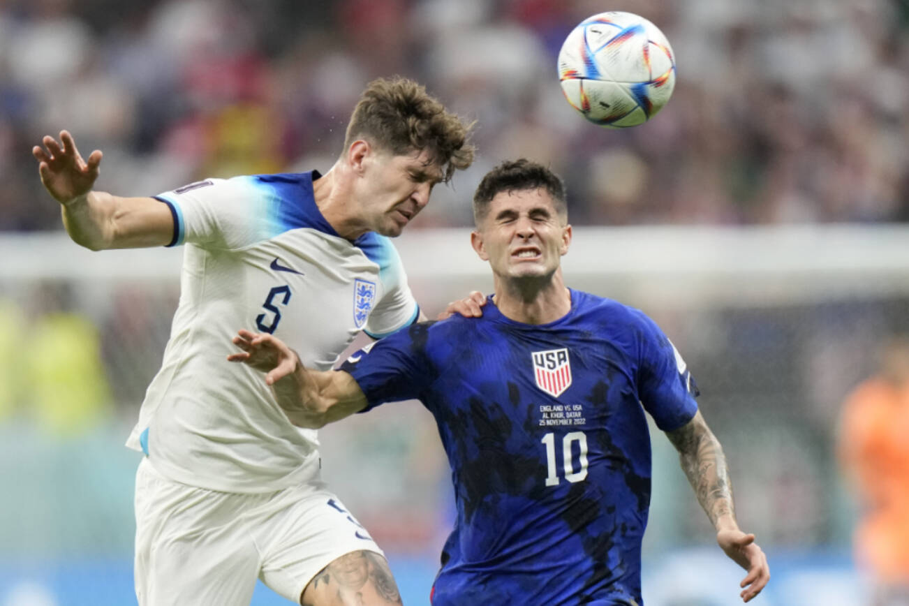 England's John Stones vies for the ball with Christian Pulisic of the United States, right, during the World Cup group B soccer match between England and The United States, at the Al Bayt Stadium in Al Khor , Qatar, Friday, Nov. 25, 2022. (AP Photo/Luca Bruno)