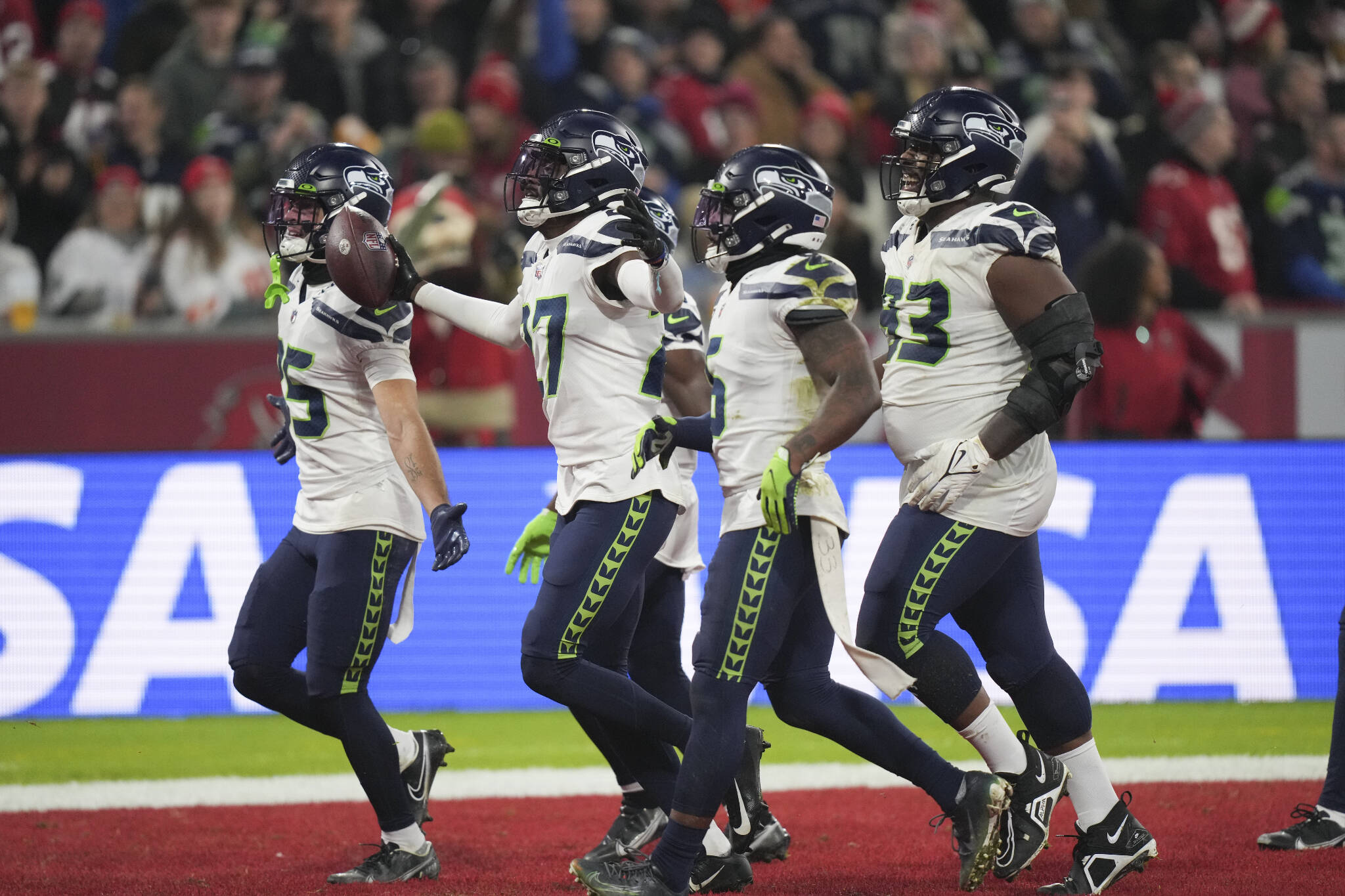 The Seahawks’ Tariq Woolen (27) reacts with teammates after his interception during the second half of a game against the Buccaneers on Nov. 13 in Munich, Germany. (AP Photo/Matthias Schrader)