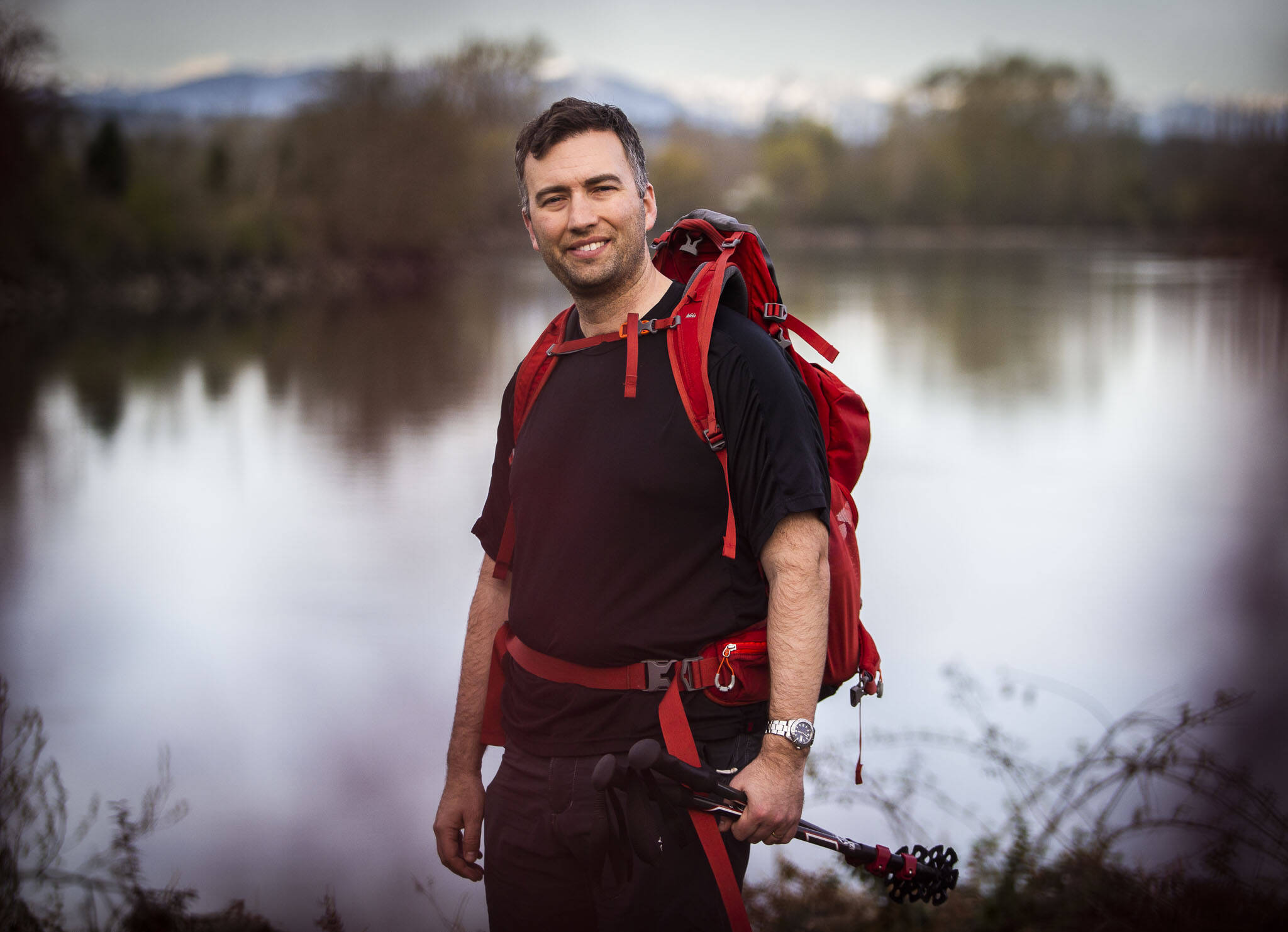 Jeff Brown at the Lowell Riverfront Trail with the Cascades visible in the distance on Thursday in Everett. (Olivia Vanni / The Herald)