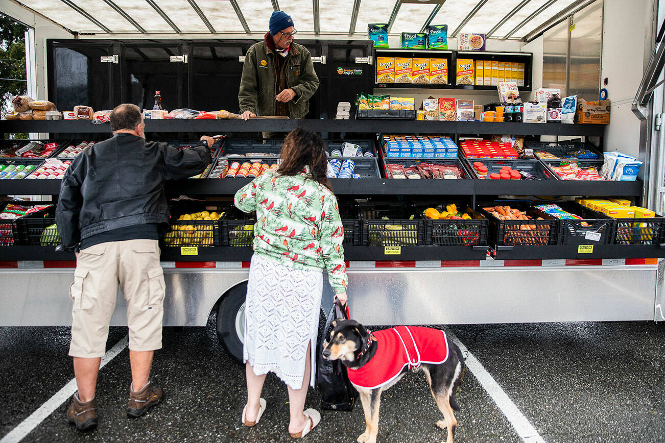 People pick up food from the Arlington Food Bank’s Mobile Market at the Stilly Valley Center on Tuesday, Nov. 22, 2022 in Arlington, Washington. (Olivia Vanni / The Herald)