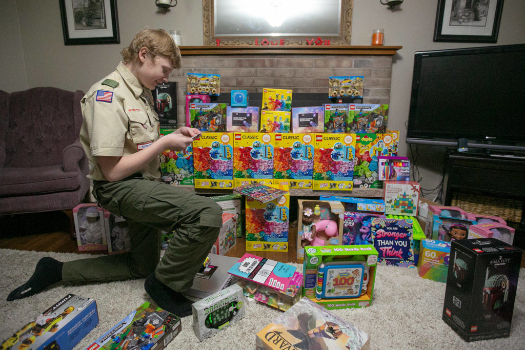 Skyler MacKay looks through some of the toys he has gathered for his Eagle Scout project. (Ryan Berry / The Herald)
