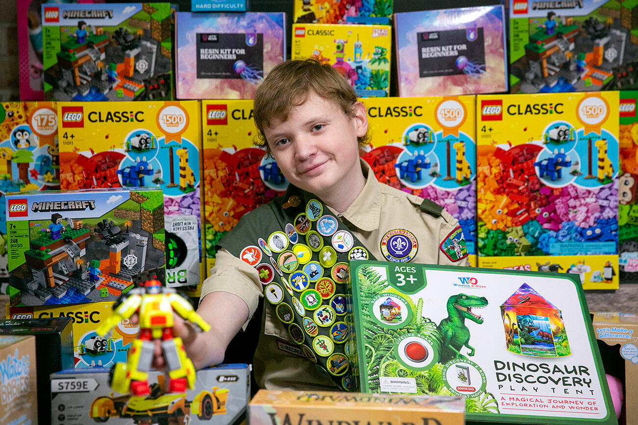 Scout Skyler MacKay, 14, sits amongst only a small number of the over 600 toys he has collected for local children in foster care as part of his Eagle Scout project Thursday, Nov. 17, 2022, at his family’s home in Lynnwood, Washington. (Ryan Berry / The Herald)