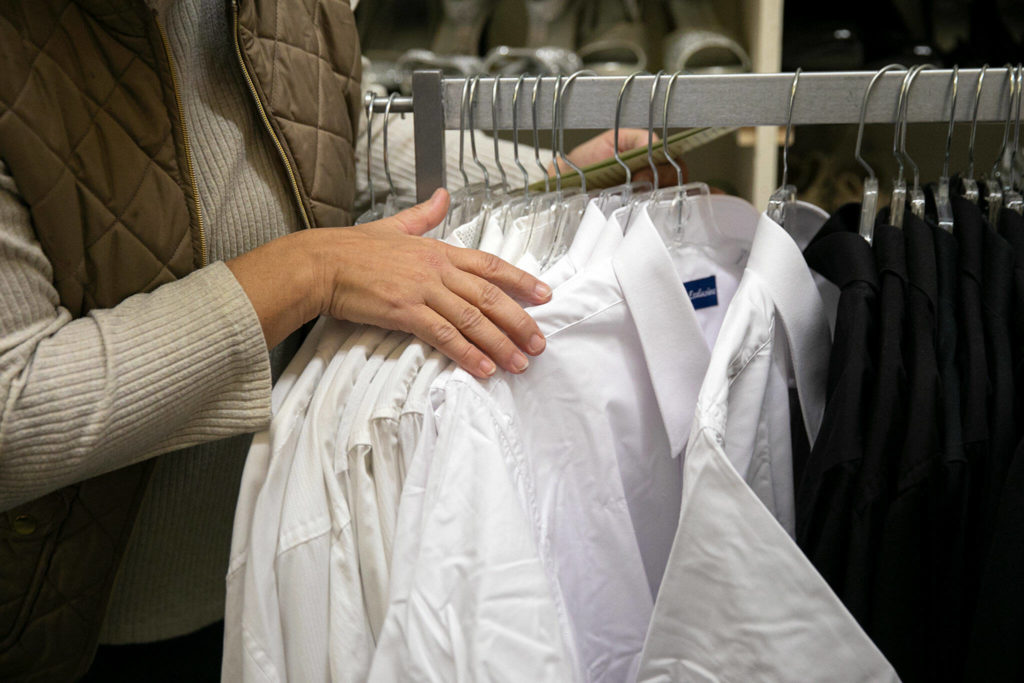 LaCrissa Spencer shows some of the rentable formal clothing used for school dances and choir concerts at Arlington Kids’ Kloset on Nov. 17, in Arlington. (Ryan Berry / The Herald)
