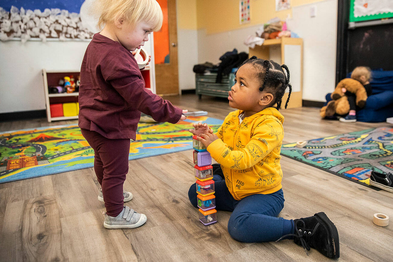 Dakota, 1, left, hands a toy wrench to Khalil, 3, during pick up time at Tomorrow's Hope Child Development Center on Wednesday, Nov. 23, 2022 in Everett, Washington. (Olivia Vanni / The Herald)