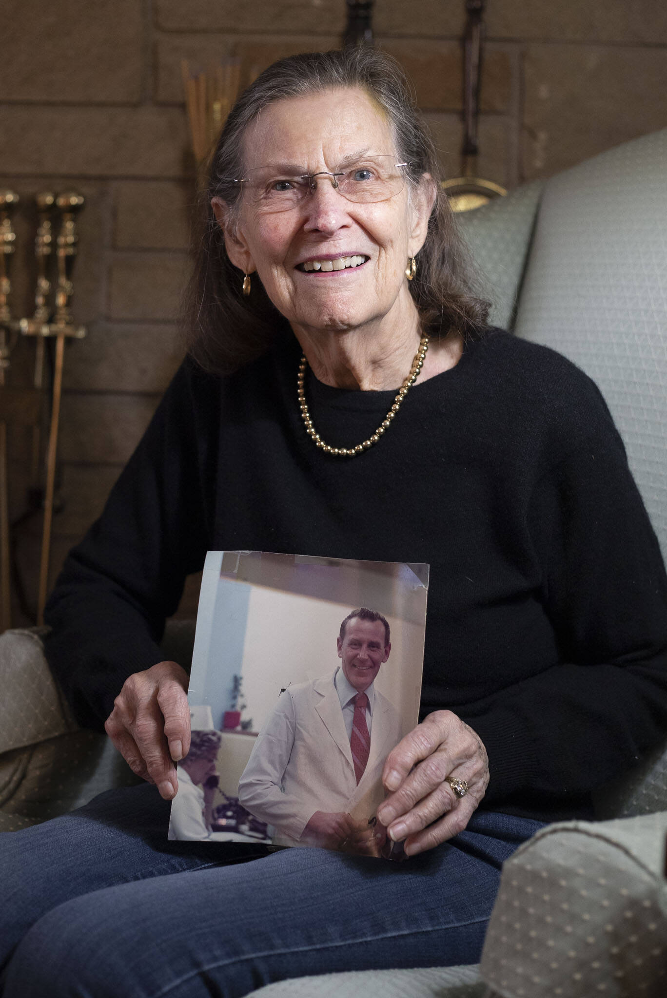 Mary Dunphy holds a photograph of her husband Dr. Barry Dunphy in his lab coat at Boeing on Dec. 1, in Seattle. (Olivia Vanni / The Herald)