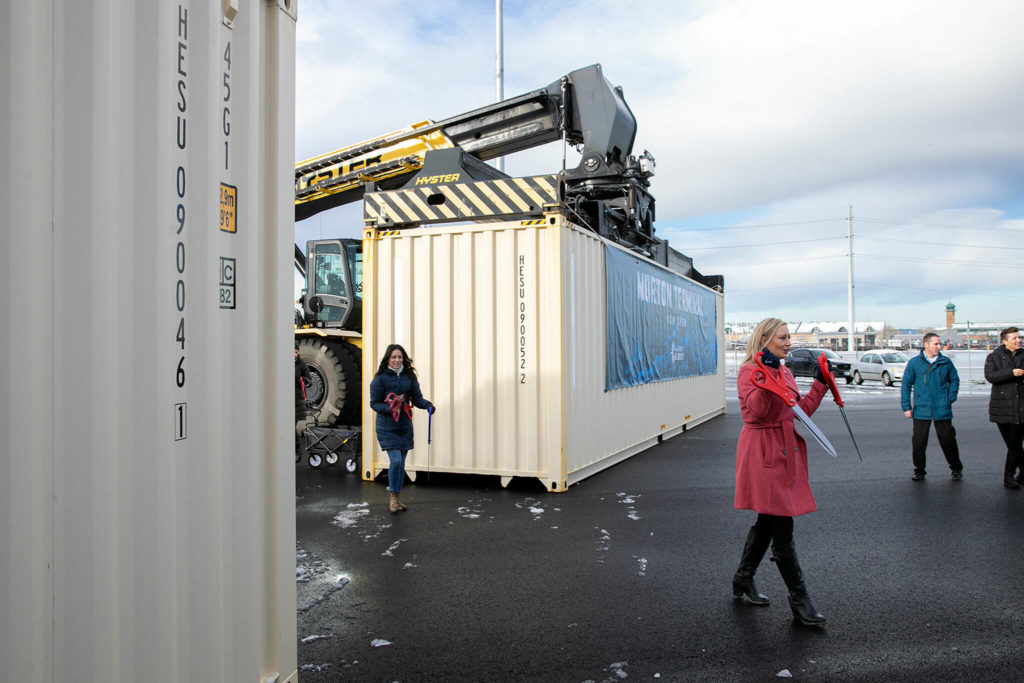 Lisa Lefeber, right, CEO at the Port of Everett, begins handing out oversized scissors for a ribbon cutting during the dedication of the new Norton Terminal on Thursday, Dec. 1, 2022, at the Port of Everett in Everett, Washington. (Ryan Berry / The Herald)
