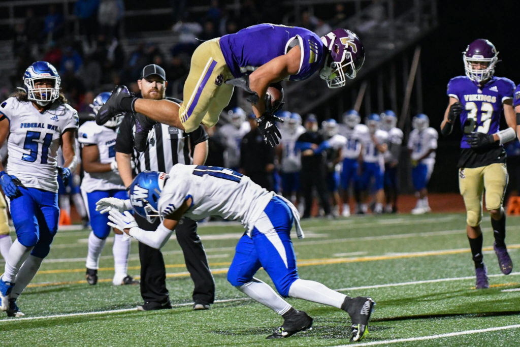 Lake Stevens’ Jayden Limar (17) leaps over a Federal Way defender for a touchdown during a game on Friday, Sept. 16, 2022, at Lake Stevens High School. (John Gardner / Pro Action Image)
