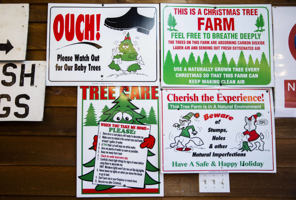 Signs alert customers to be aware of where they are walking at Pilchuck Secret Valley Tree Farm on Monday, in Arlington. (Olivia Vanni / The Herald) 
