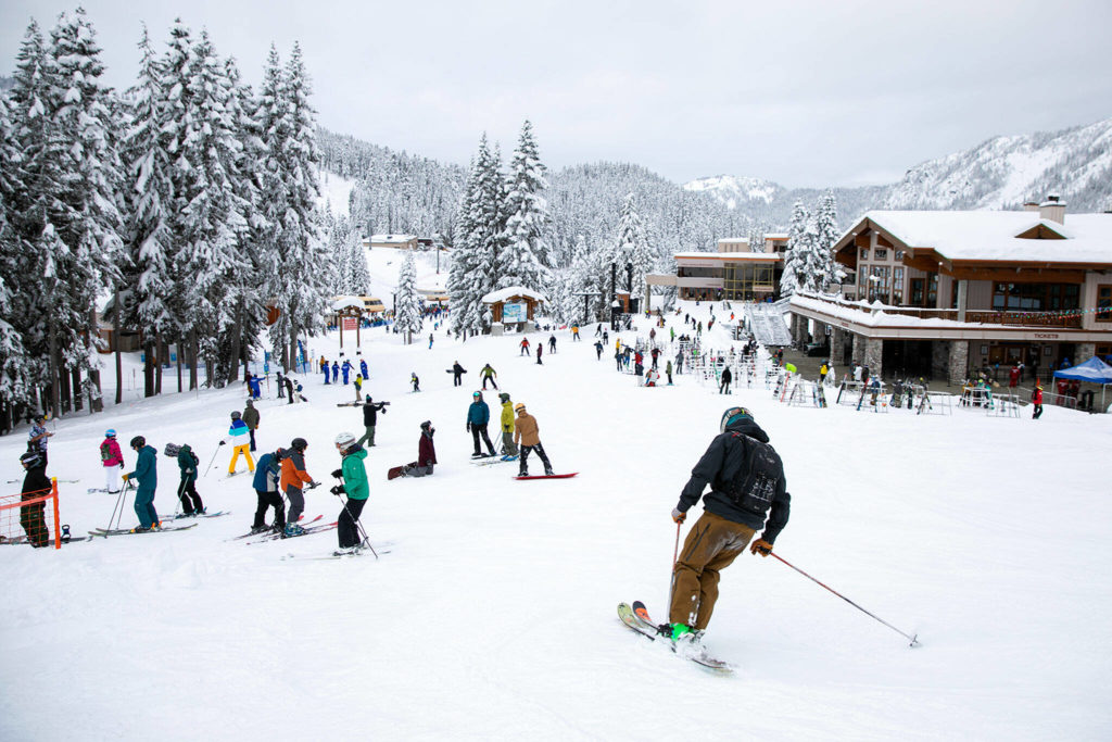 Visitors travel between lodges and lifts on the opening day of ski season. (Ryan Berry / The Herald)
