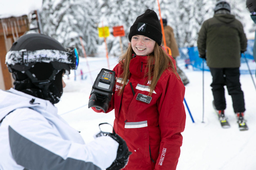 Madeline Stewart, working her first season at Stevens Pass, scans passes on the opening day of ski season at Stevens Pass Ski Area. (Ryan Berry / The Herald)
