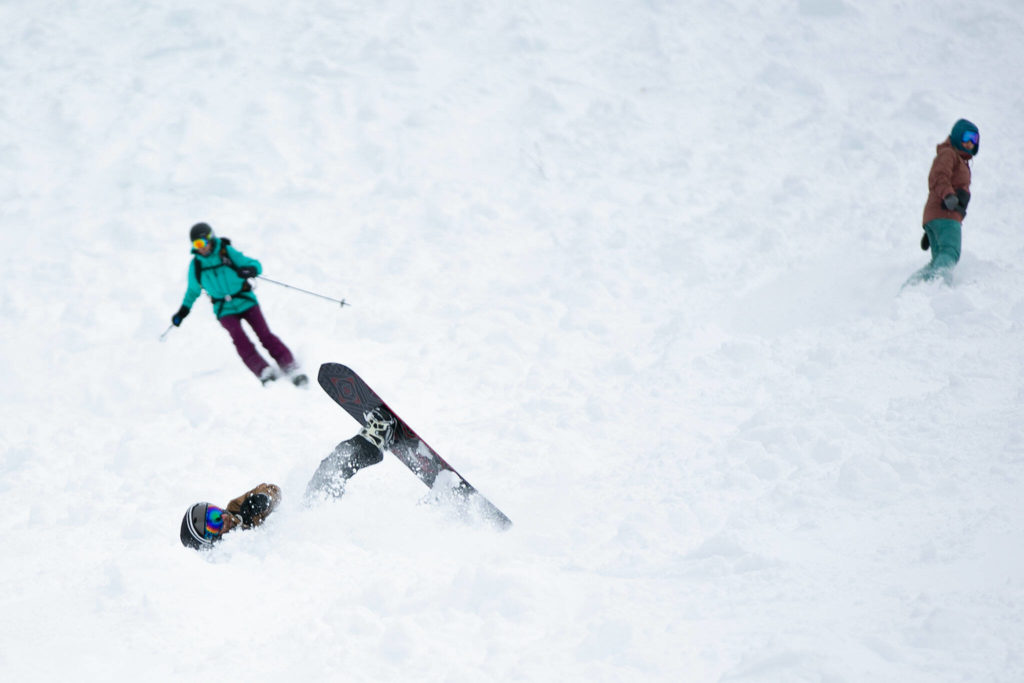 A snowboarder wipes out before getting right back up and finishing the run. (Ryan Berry / The Herald)
