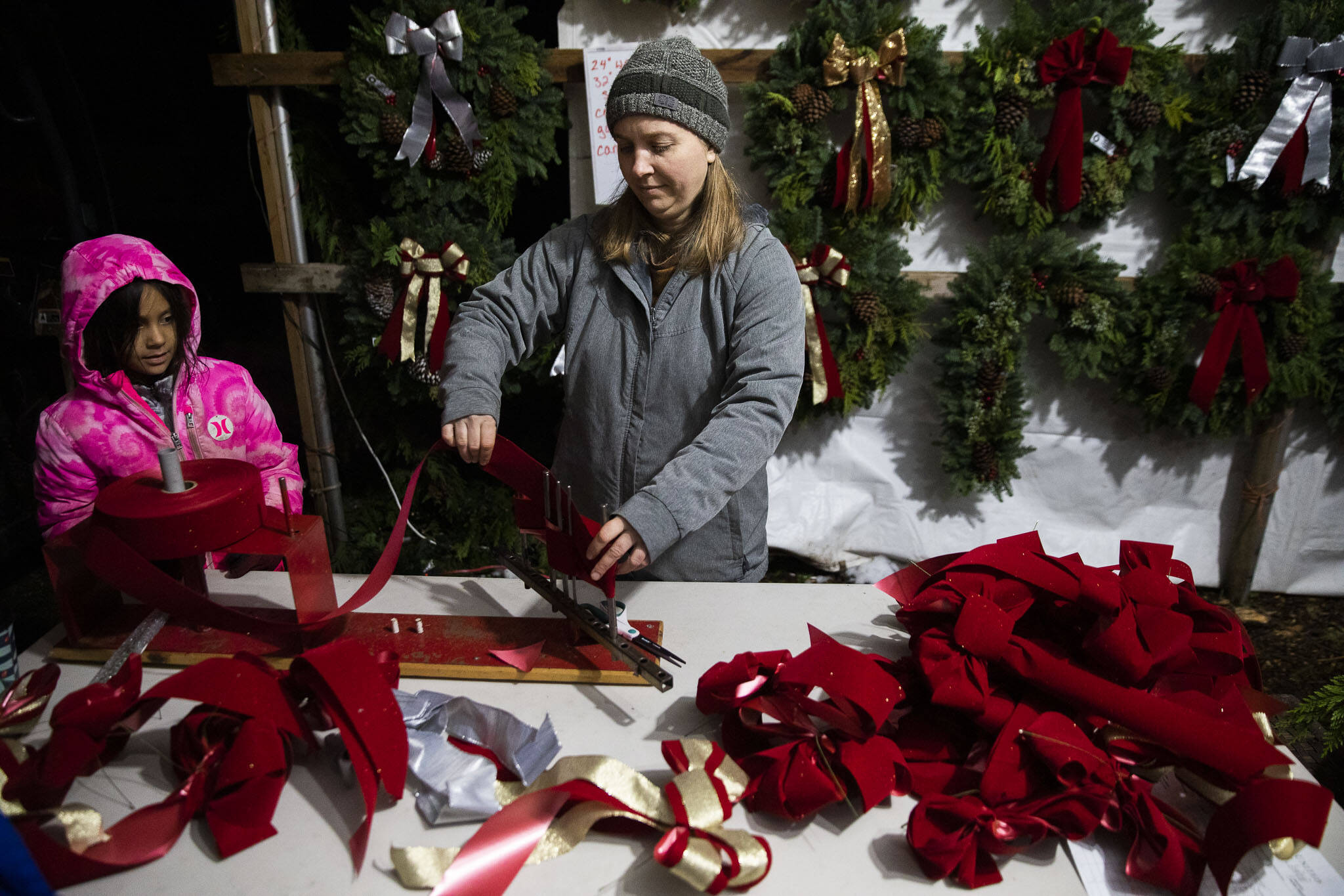 Mollie Rodriguez works on assembling bows for wreaths at the workshop on Dec. 5, in Monroe. (Olivia Vanni / The Herald)