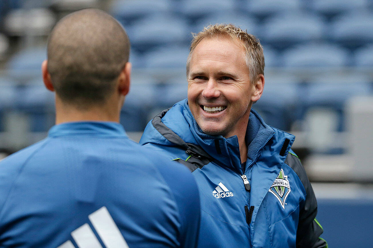 Seattle Sounders sporting director Chris Henderson greets a player after a soccer training session Monday, Feb. 22, 2016, in Seattle. The Sounders play Club America in the CONCACAF Champions League quarterfinal round on Tuesday. (AP Photo/Elaine Thompson)