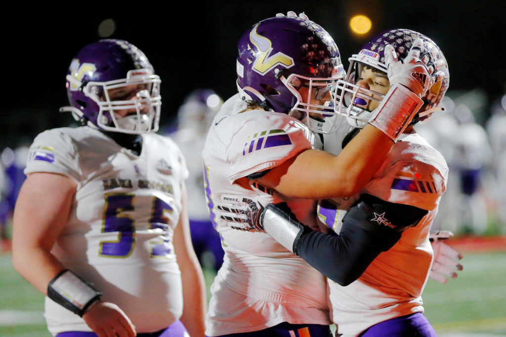 Lake Stevens star running back Jayden Limar (right) celebrates with two offensive linemen after scoring on the opening drive. (Ryan Berry / The Herald)
