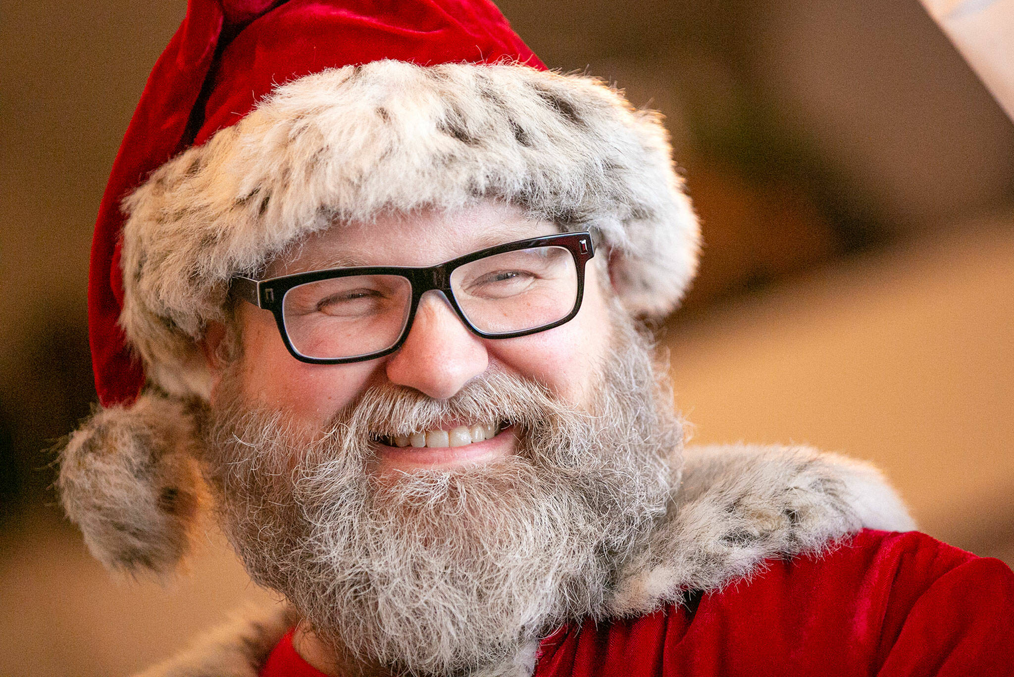 Santa Brett Nichols cracks a smile with a twinkle in his eye on Dec. 4, in Monroe. After a year of health issues, Nichols recently discovered he has oligodendroglioma, a type of slow growing brain cancer, and has begun the process of determining the best path forward. Prior to his first biopsy, he and his longtime partner Tami got married in a last-minute ceremony put together by family at Snoqualmie Pass on Nov. 20. (Ryan Berry / The Herald)