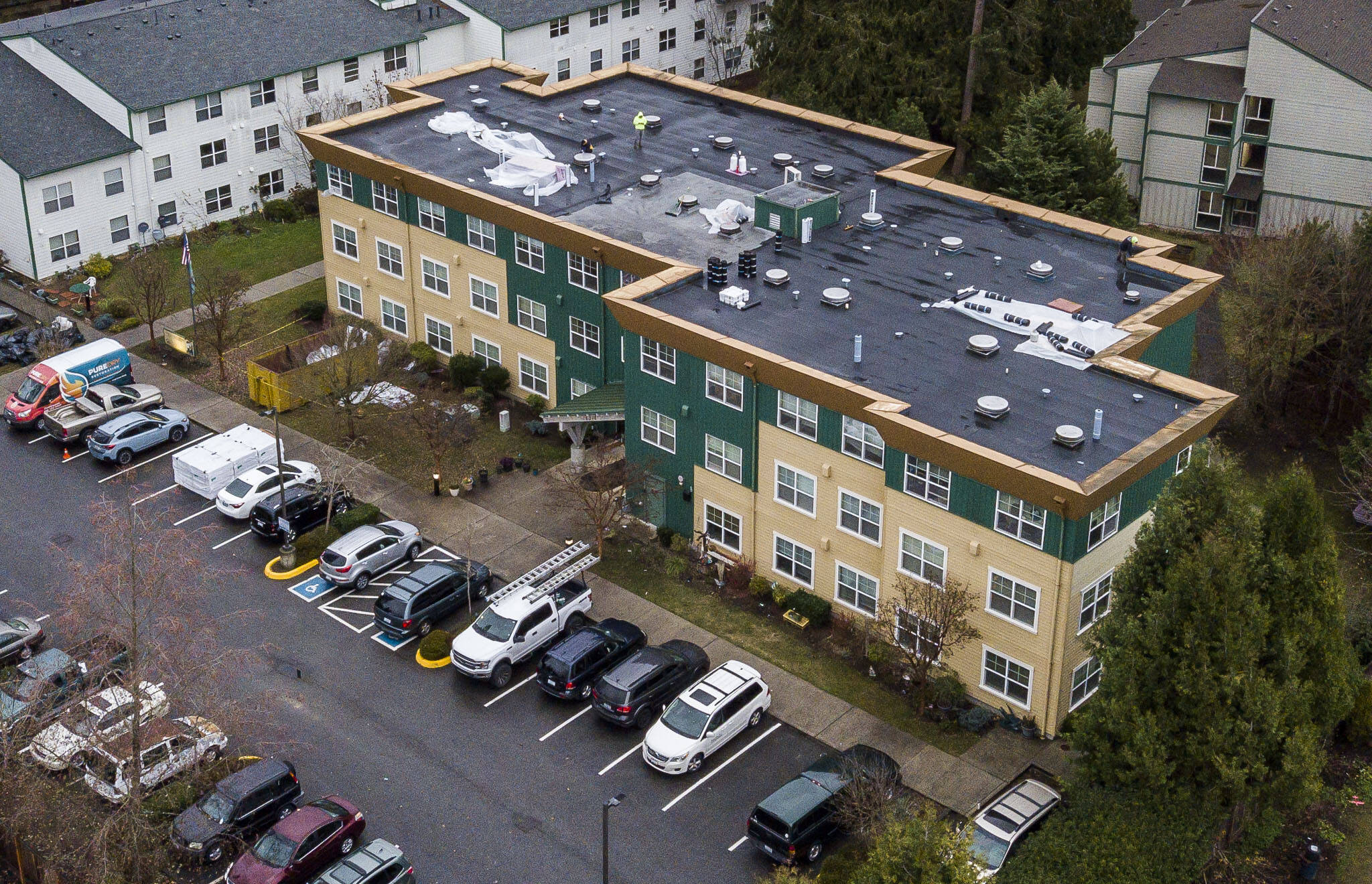 People work on the roof of the Stilly Valley Senior Center on Thursday, in Arlington. (Olivia Vanni / The Herald)