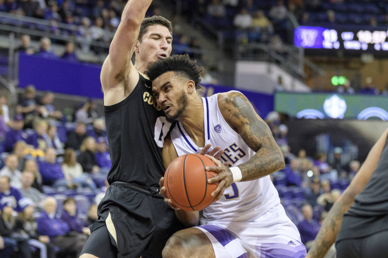 Washington guard Jamal Bey drives with the basketball against Colorado guard Luke O'Brien during the first half of an NCAA college basketball game, Sunday, Dec. 4, 2022, in Seattle. (AP Photo/Caean Couto)