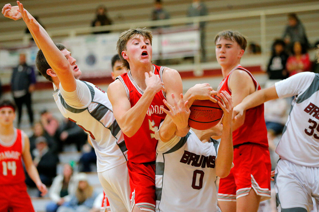 Cascade’s Aidan Kopra and Stanwood’s Gary Grisham wrestle for a loose ball during a game Thursday, Dec. 8, 2022, at Cascade High School in Everett, Washington. (Ryan Berry / The Herald)