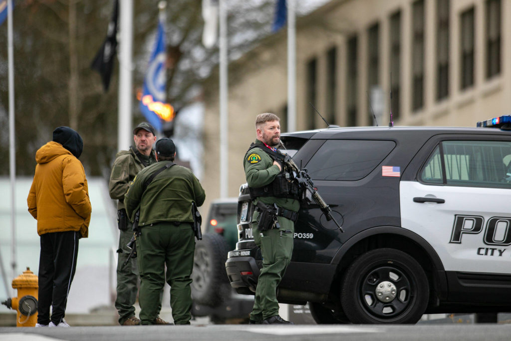 Armed police wait outside the Snohomish County Superior Courthouse while dealing with an armed person inside Monday, in downtown Everett. (Ryan Berry / The Herald)
