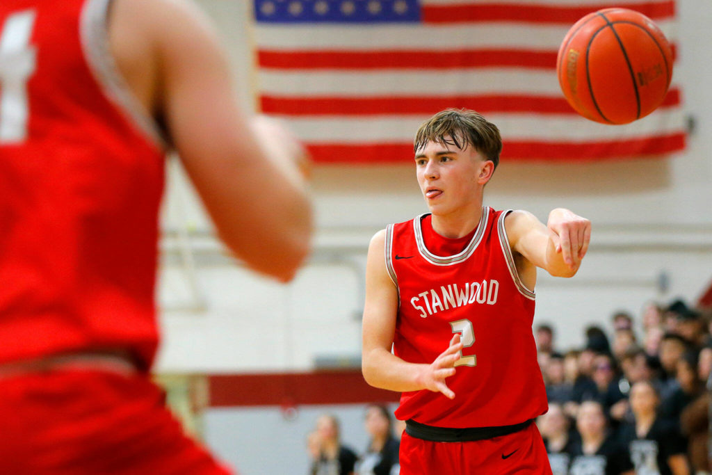 Stanwood’s John Floyd makes a no-look pass to a teammate against Cascade on Dec. 8 at Cascade High School in Everett. (Ryan Berry / The Herald)
