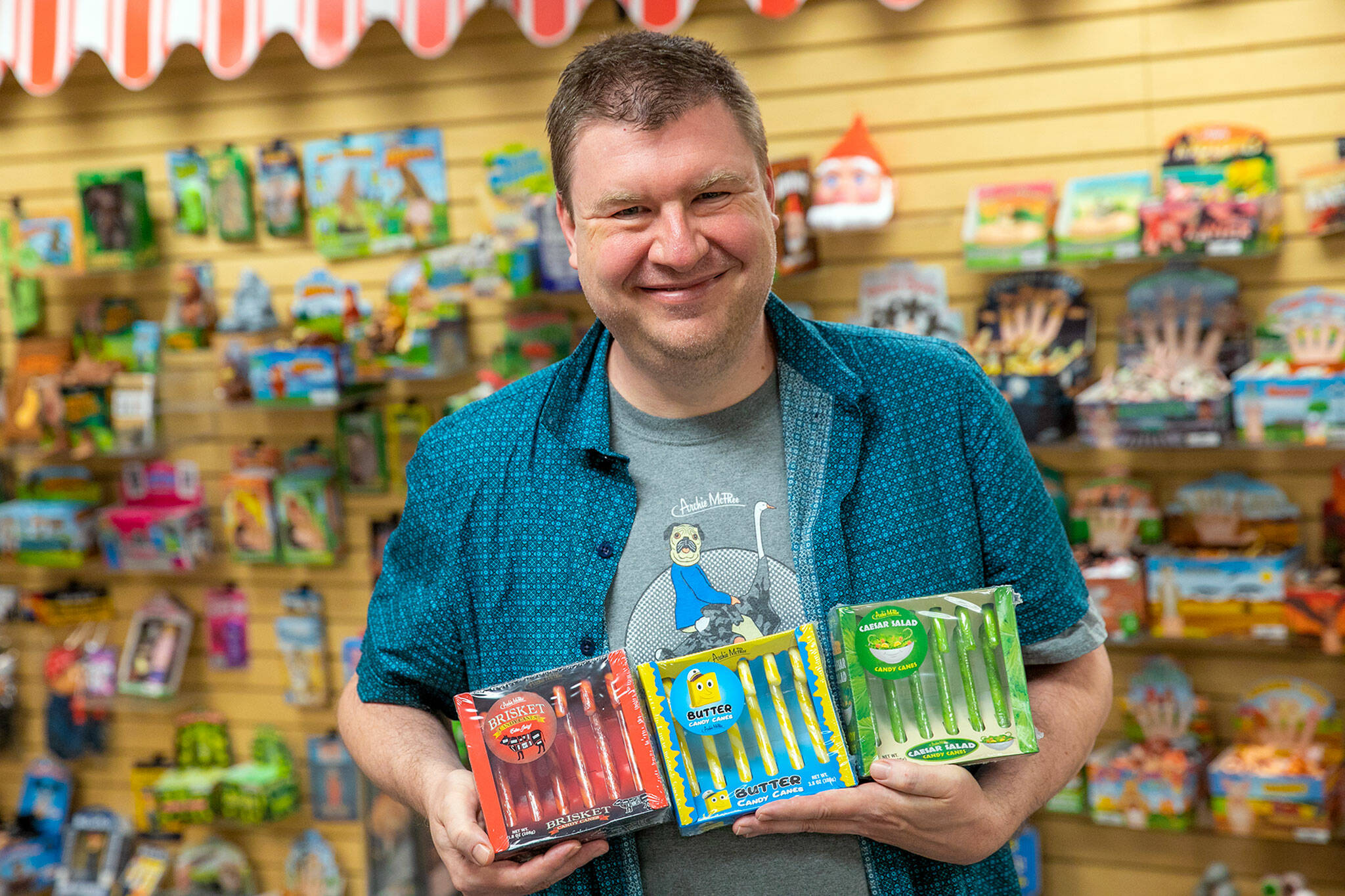 David Wahl, Director of Awesome at Archie McPhee, holds this season’s three new candy cane flavors: brisket, butter and Caesar salad. (Ryan Berry / The Herald)