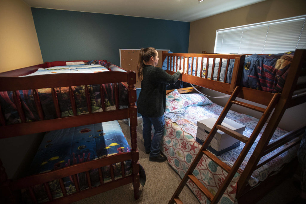 Zoë Nina finishes making a bed in the new Interfaith Family Shelter on Thursday, in Everett. (Olivia Vanni / The Herald)
