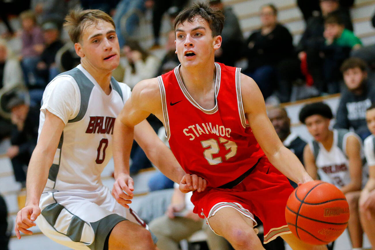 Stanwood’s Cole Williams dribbles past a defender on his way to the net against Cascade on Thursday, Dec. 8, 2022, at Cascade High School in Everett, Washington. (Ryan Berry / The Herald)