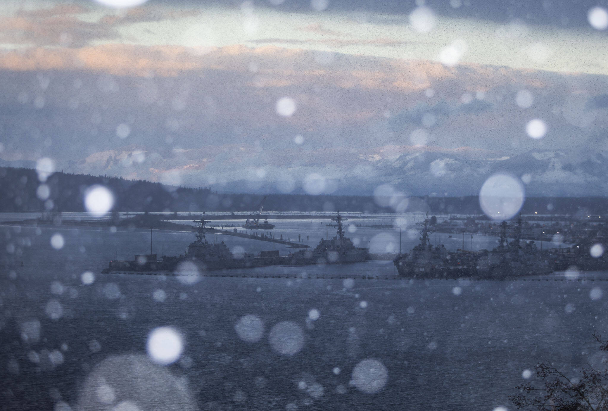 Snow begins to fall over Everett as the sun sets on Sunday, Dec. 18, 2022 in Everett, Washington. (Olivia Vanni / The Herald)