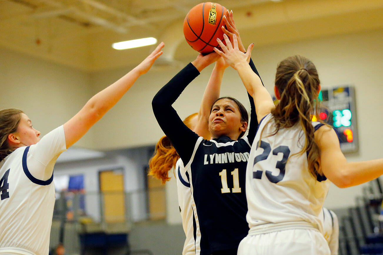 Lynnwood’s Teyah Clark gets pestered by a number of Seagulls while trying to get off a shot against Everett on Thursday, Dec. 15, 2022, at Norm Lowery Gymnasium in Everett, Washington. (Ryan Berry / The Herald)