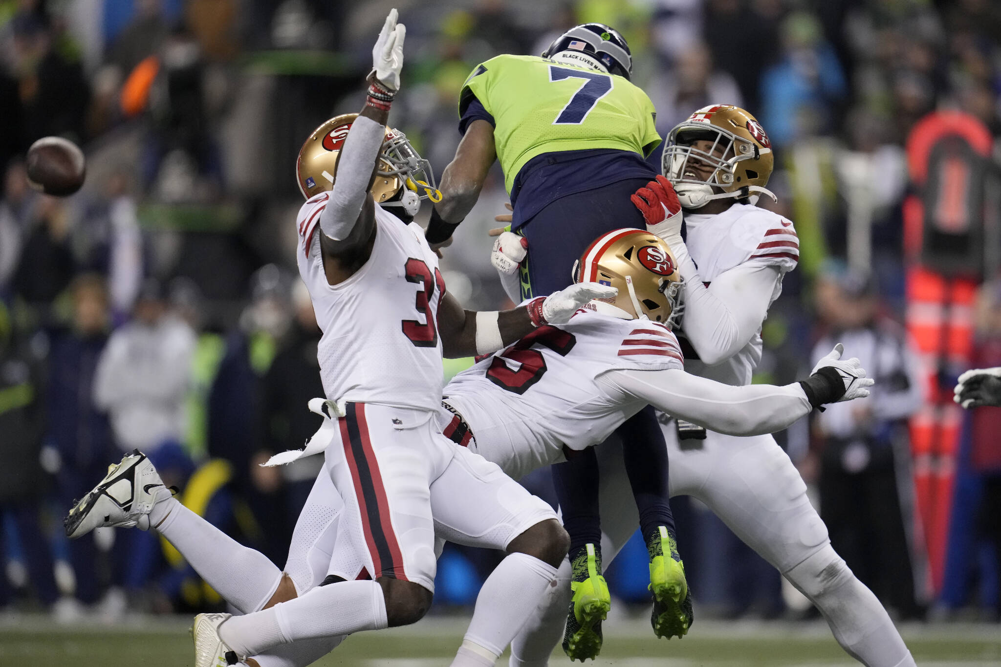 Seahawks quarterback Geno Smith (7) gets rid of the ball while pressured by 49ers safety Tashaun Gipson Sr. (left), defensive end Jordan Willis (middle) and defensive end Drake Jackson during the second half of a game Thursday night in Seattle. (AP Photo/Marcio Jose Sanchez)