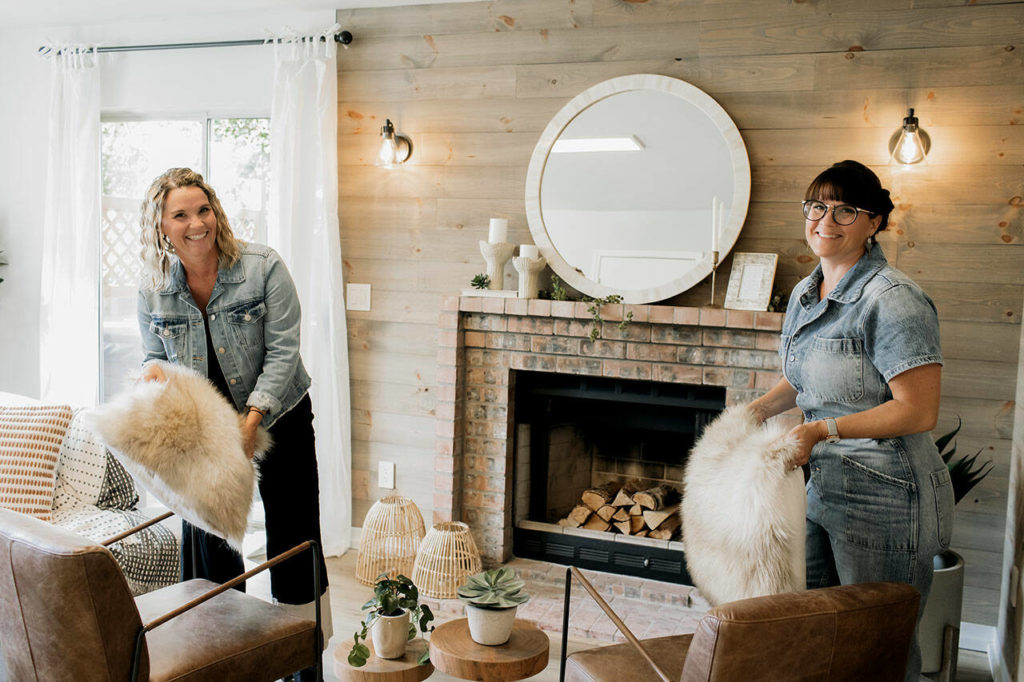 Real Estate consultants and twin sisters Leslie Davis and Lyndsay Lamb staging in the newly renovated downstairs family room in the Thaut House, as seen on “Unsellable Houses.” (HGTV)
