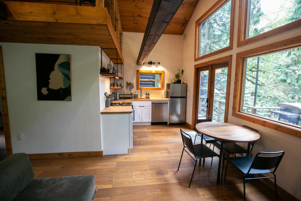 Light shines in on a kitchen and dining space in Cabin 3 at Canyon Creek Cabins on Friday, Sep. 23, 2022, in Granite Falls, Washington. (Ryan Berry / The Herald)
