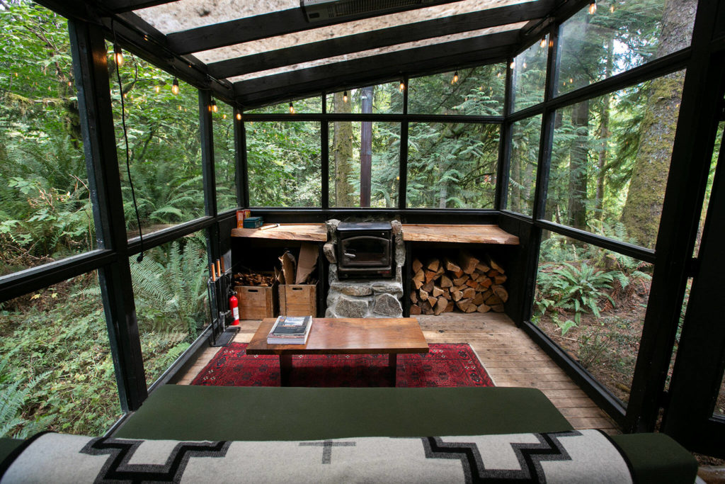 At 375 square feet, Cabin 2 is the smallest unit at Cabin Creek Cabins. Shown here is a sunroom with a sofa and a fireplace. (Ryan Berry / The Herald)
