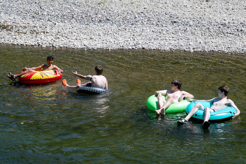 Teenagers tube the waters of the Pilchuck River Wednesday afternoon in Snohomish, Washington on July 20, 2022. (Kevin Clark / The Herald)
