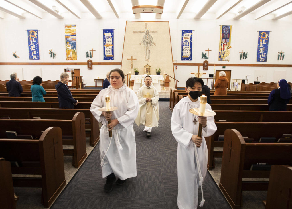 Father Tuan Nguyen walks down the aisle at the end of morning mass at Immaculate Conception Church on Wednesday, May 4, 2022 in Everett, Washington. (Olivia Vanni / The Herald)
