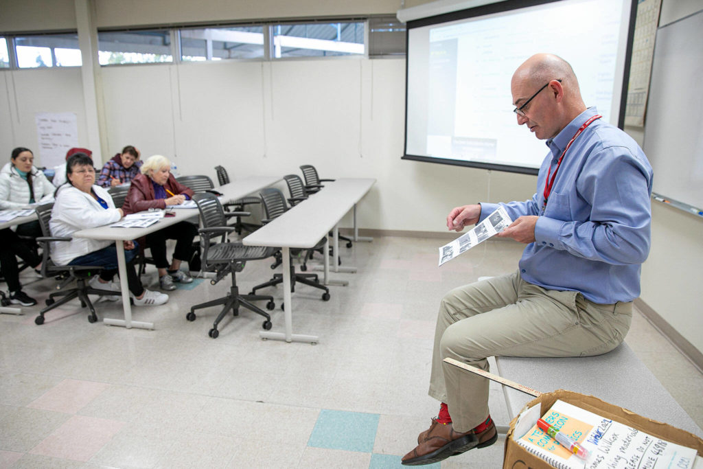 Senior Associate Professor James Willcox reads through worksheet answers in an ESL class at Everett Community College on Monday, Oct. 24, 2022, in Everett, Washington. (Ryan Berry / The Herald)
