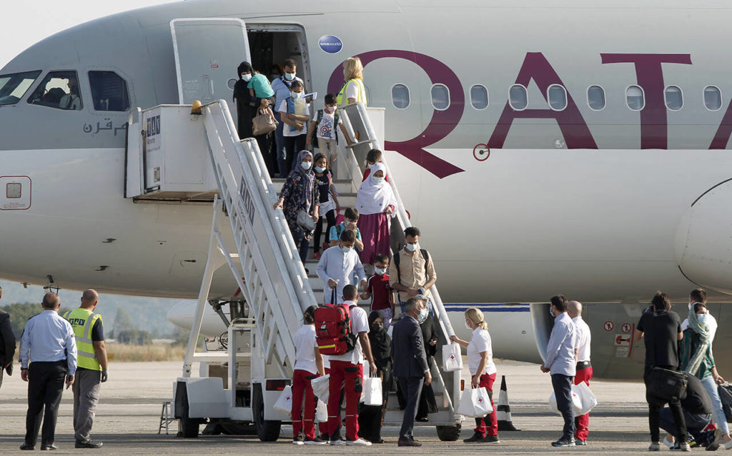 Afghan evacuees disembark the plane and board a bus after landing at Skopje International Airport, North Macedonia, on Wednesday, Sept. 15, 2021. North Macedonia has hosted another group of 44 Afghan evacuees on Wednesday where they will be sheltered temporarily till their transfer to final destinations. (AP Photo/Boris Grdanoski)
