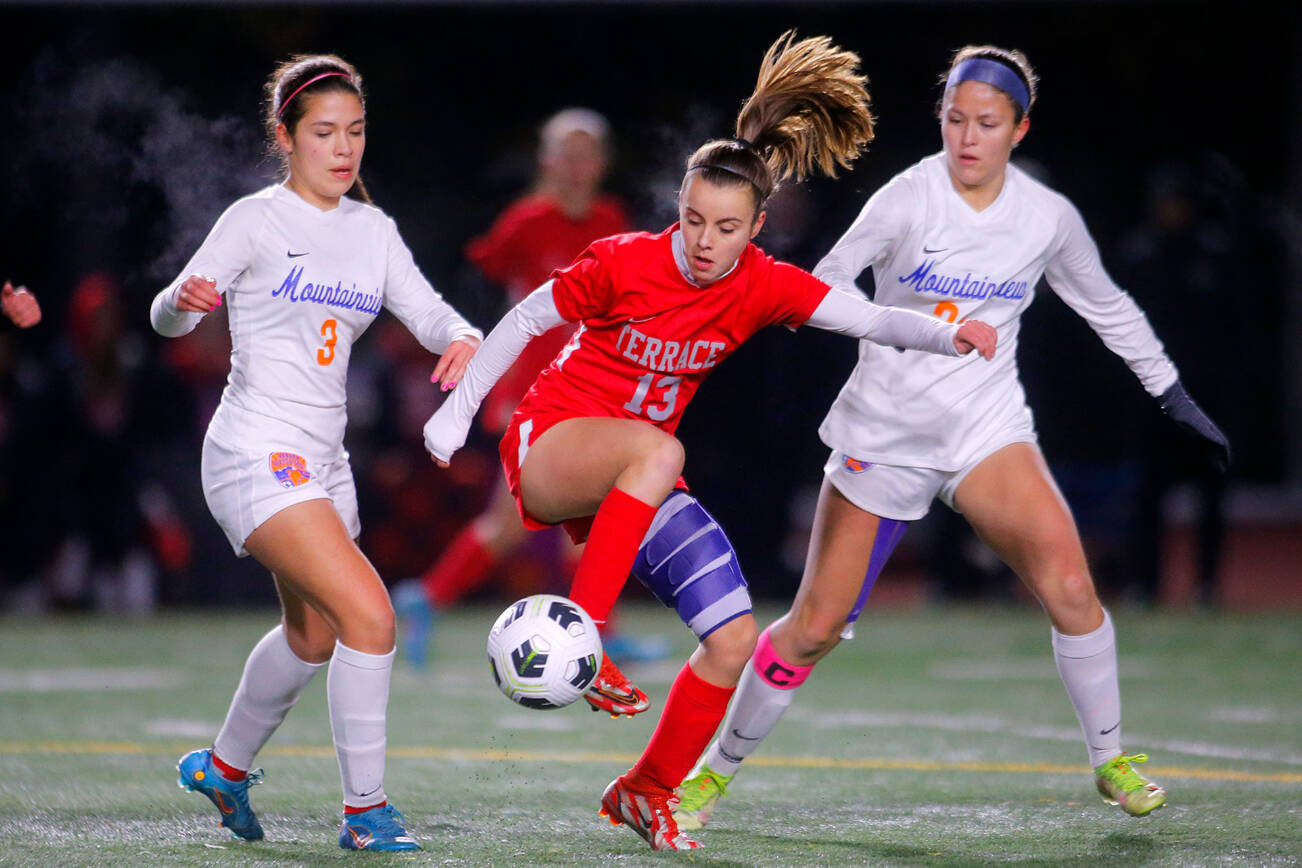 Mountlake Terrace’s Natalie Cardin keeps the ball away from Auburn Mountainview’s Lucy Montiel and Kamryn Kuolt during a first round game in the 3A State Tournament on Wednesday, Nov. 9, 2022, Edmonds District Stadium in Edmonds, Washington. (Ryan Berry / The Herald)
