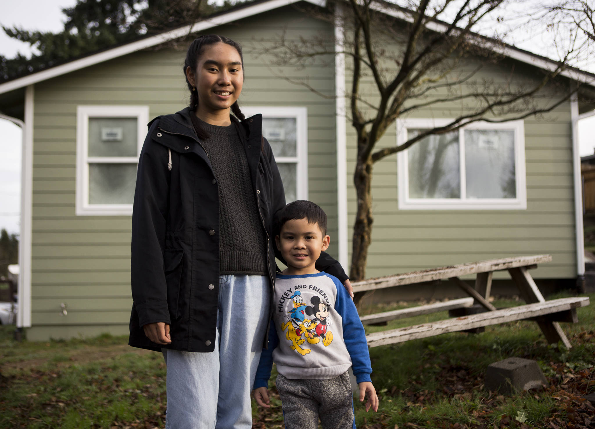 Myli Maytrichith, 12, and little brother Tyson, 4, stand outside their Everett home that is currently being rebuilt after it caught fire last March. (Olivia Vanni / The Herald)