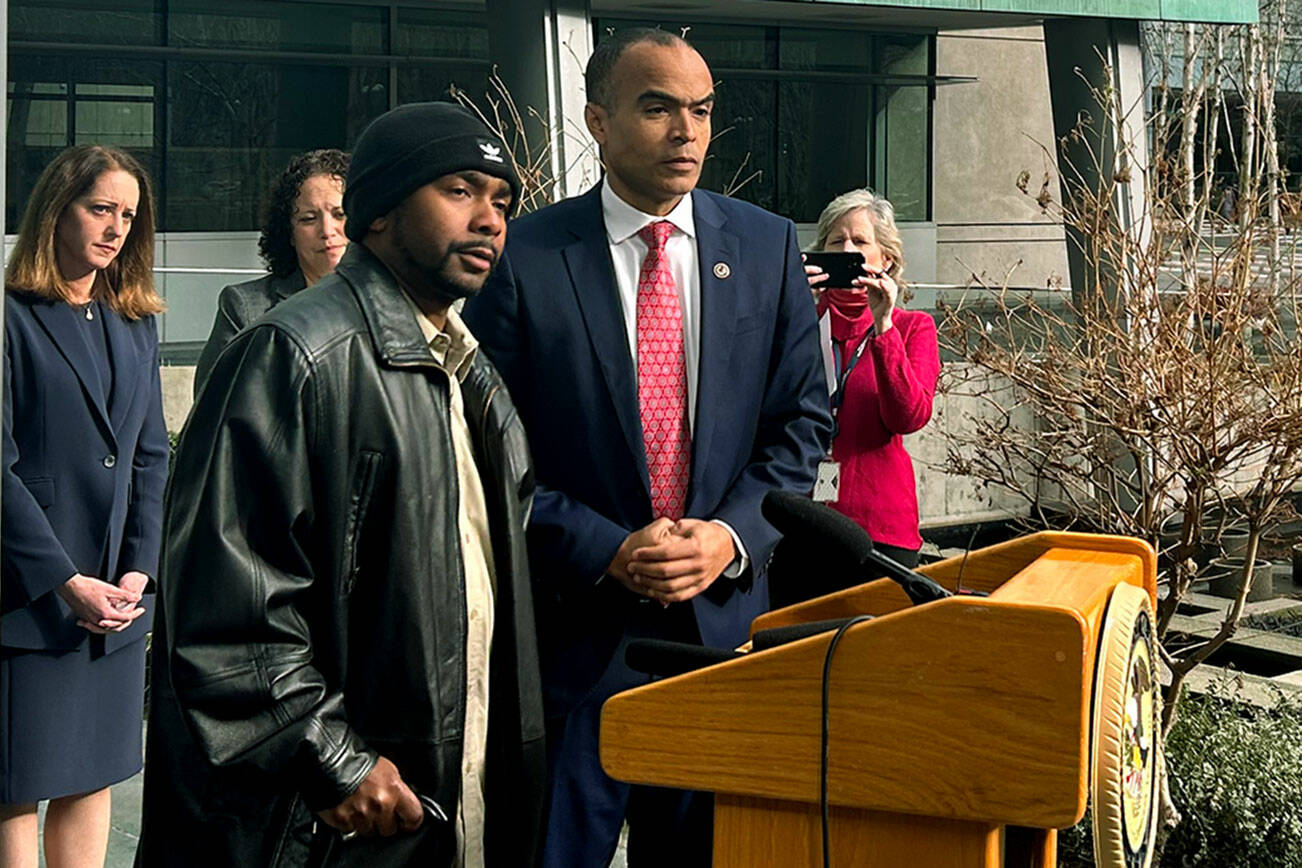 U.S. Attorney Nick Brown and the victim of a brutal attack in 2018 answer questions from reporters on Jan. 27, 2023 in Seattle, Washington. (Jake Goldstein-Street / The Herald)