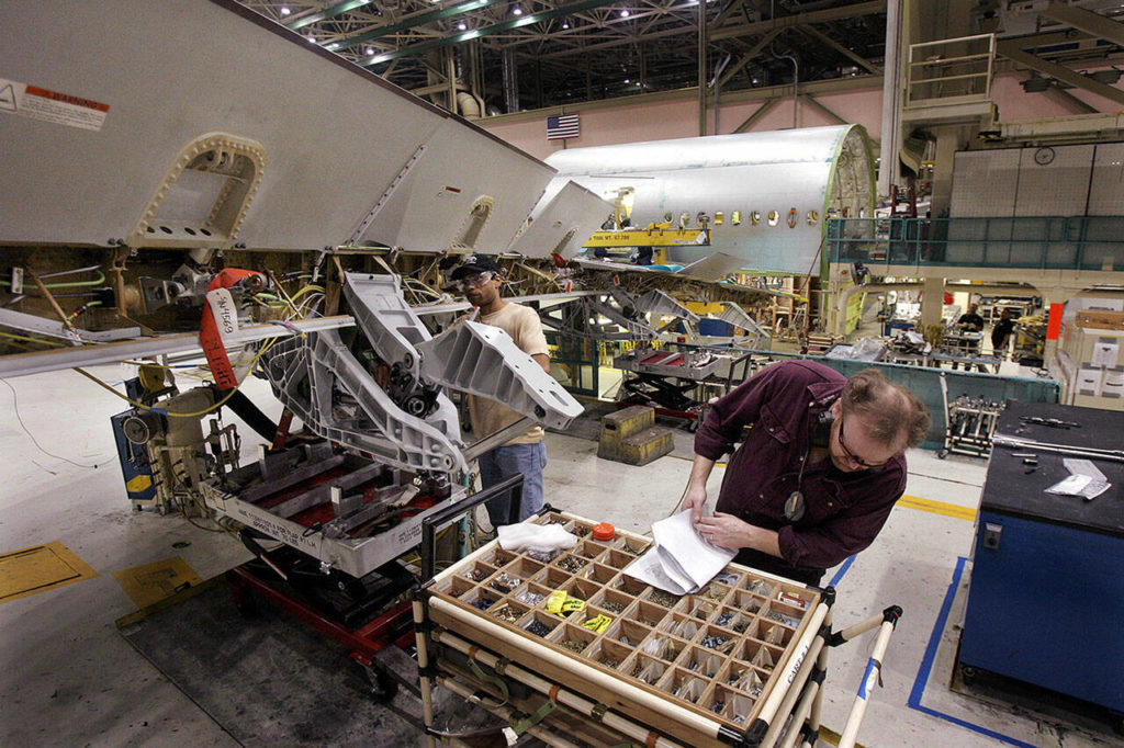 Boeing employees work near the wing assembly of a Boeing 777 on Oct. 26, 2005 at the company’s manufacturing plant in Everett. (AP Photo / Elaine Thompson)
