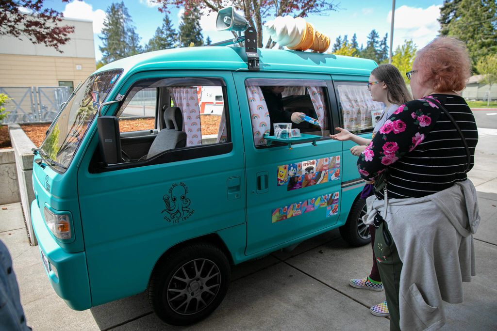 Eleven-year-old Gabe Fitzpatrick serves ice cream out of his parents’ Yay Big Yay High Yay Ice Cream Truck on May 14, outside Eisenhower Middle School in Everett. (Ryan Berry / The Herald)
