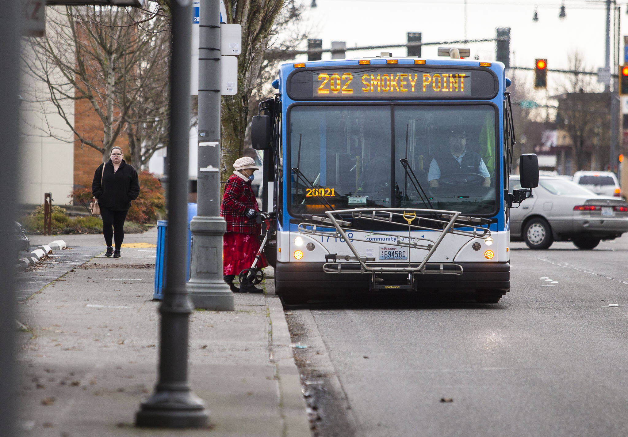 A transit rider steps onto a Community Transit bus on Tuesday, Jan. 3, 2023 in Everett, Washington. (Olivia Vanni / The Herald)