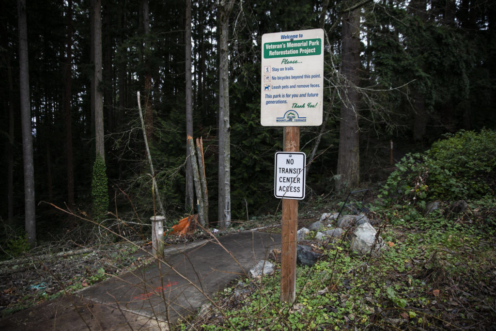 A sign for Veterans Memorial Park indicates no access to the transit center on Jan. 9, in Mountlake Terrace. The city plans to pave a path that complies with the Americans with Disabilities Act and install lighting. (Olivia Vanni / The Herald)
