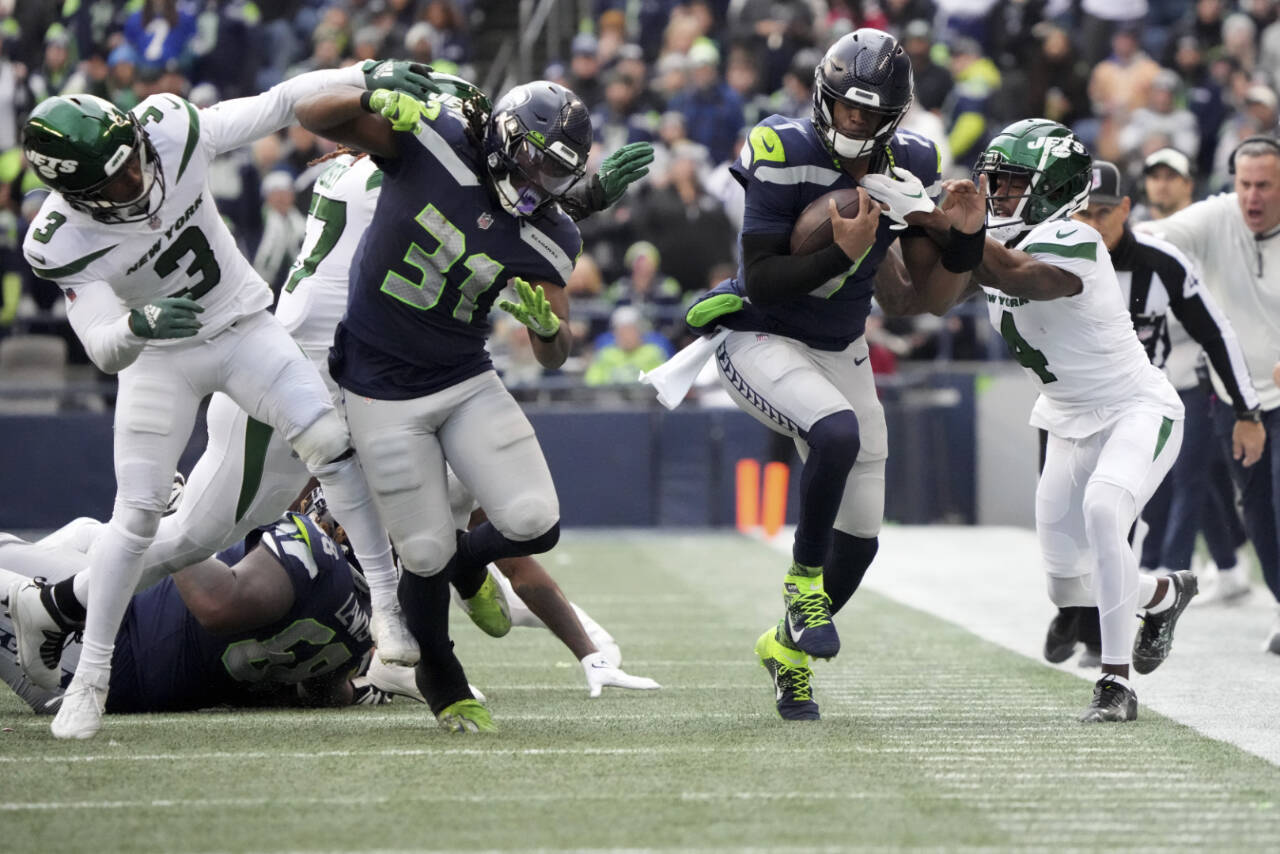 Seattle Seahawks quarterback Geno Smith runs for a first down as New York Jets cornerback D.J. Reed (4) defends during a game Jan. 1 in Seattle. (AP Photo/Ted S. Warren)