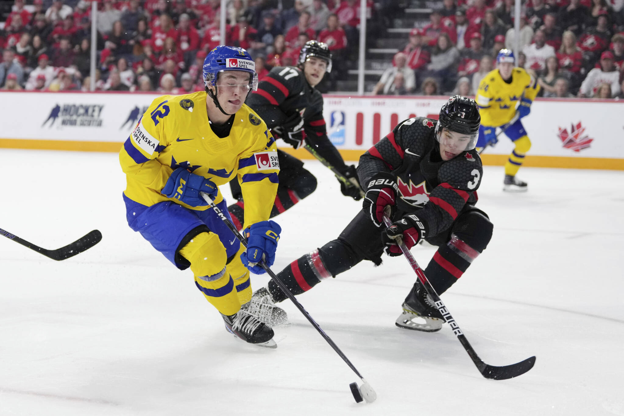 Sweden’s Noah Ostlund, left, protects the puck from Canada’s Olen Zellweger during a World Junior Hockey Championships game Dec. 31, 2022, in Halifax, Nova Scotia. Zellweger, a defenseman for the Everett Silvertips, helped Canada win the tournament. (Darren Calabrese/The Canadian Press via AP)