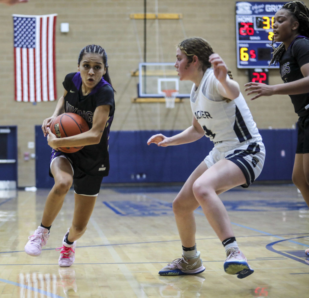 Lake Stevens’ Perla Ruiz moves with the ball against Glacier Peak’s Byrnna Pukis (3) during a game between the Lake Stevens Vikings and Glacier Peak Grizzlies on Friday in Snohomish. The Grizzlies won 51-32. (Annie Barker / The Herald)
